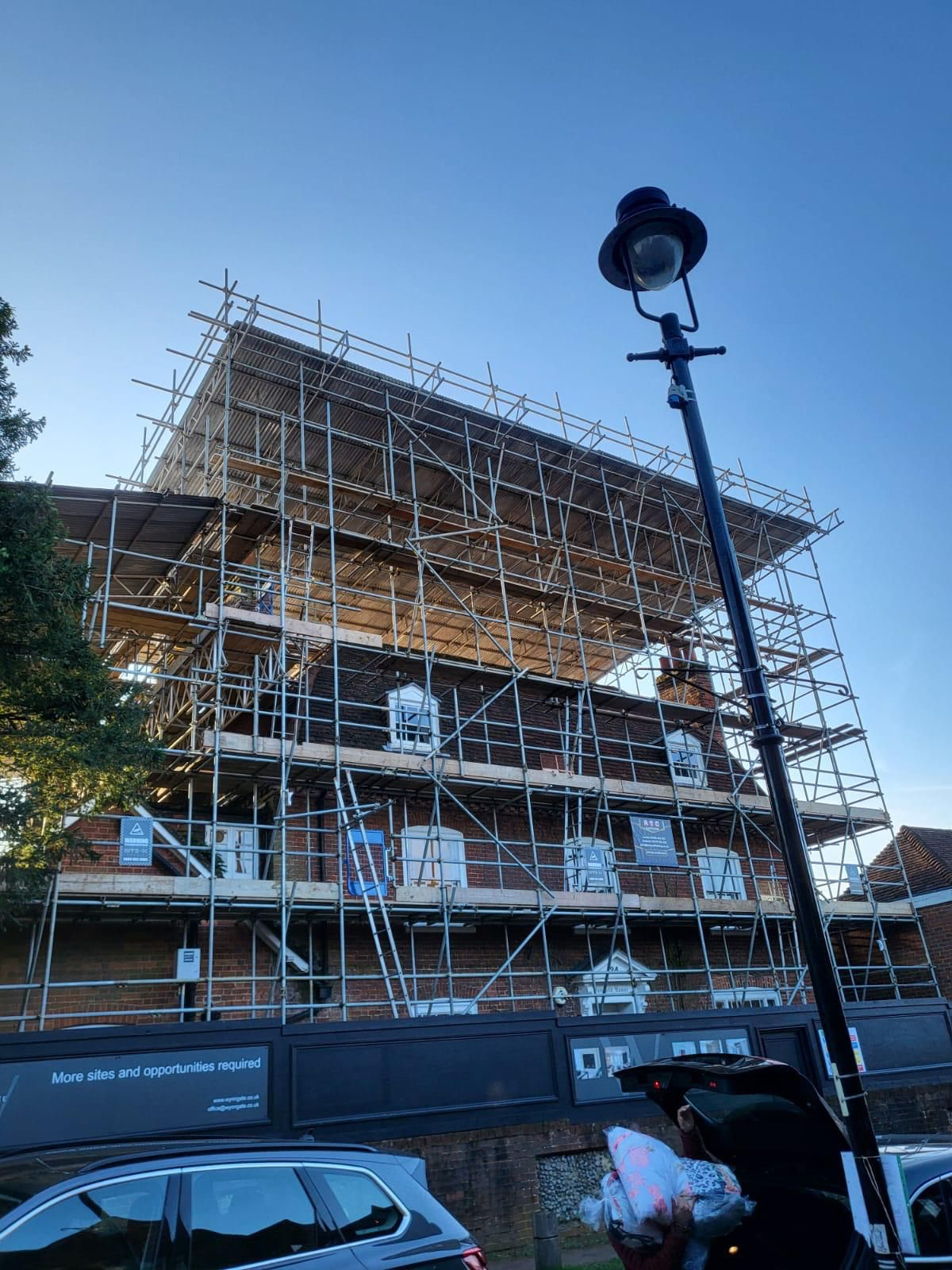 Temporary roof scaffold spanning a large residential building during redevelopment