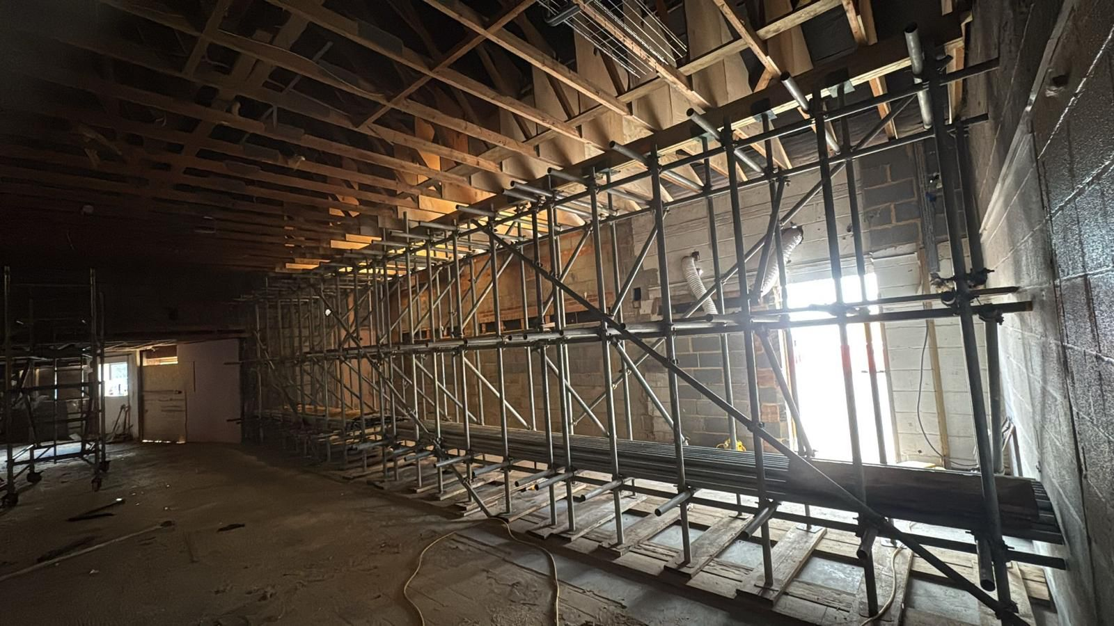 Back propping and needle support scaffold installed inside a stripped-out building to carry the roof structure