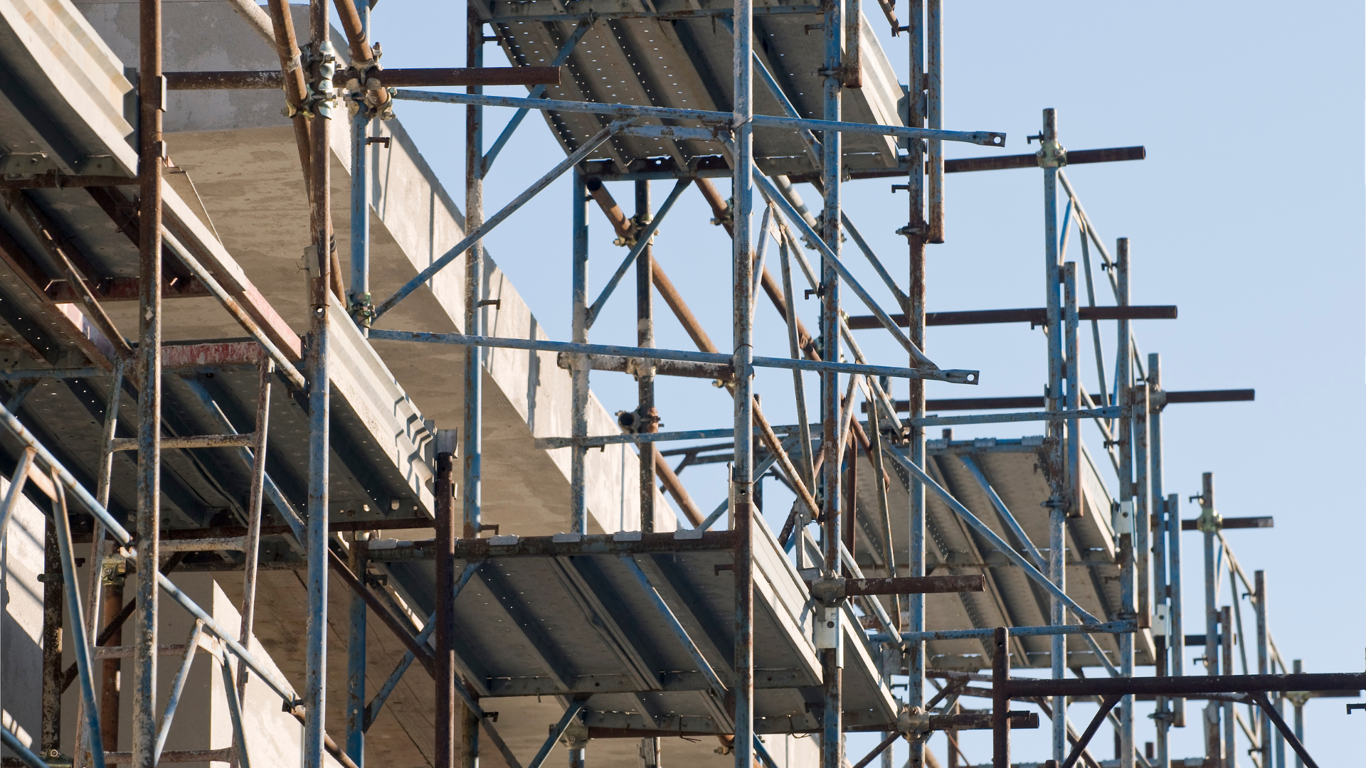 Birdcage scaffold with multiple boarded lifts filling a tall interior hall for soffit and ceiling access