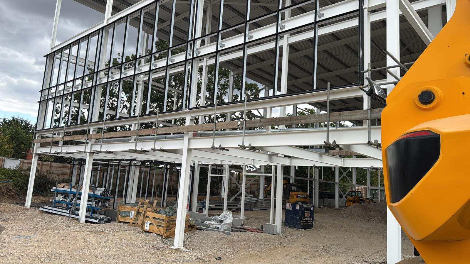 Edge protection and scaffold tube guardrails fitted to the open first floor edge of a steel frame commercial building