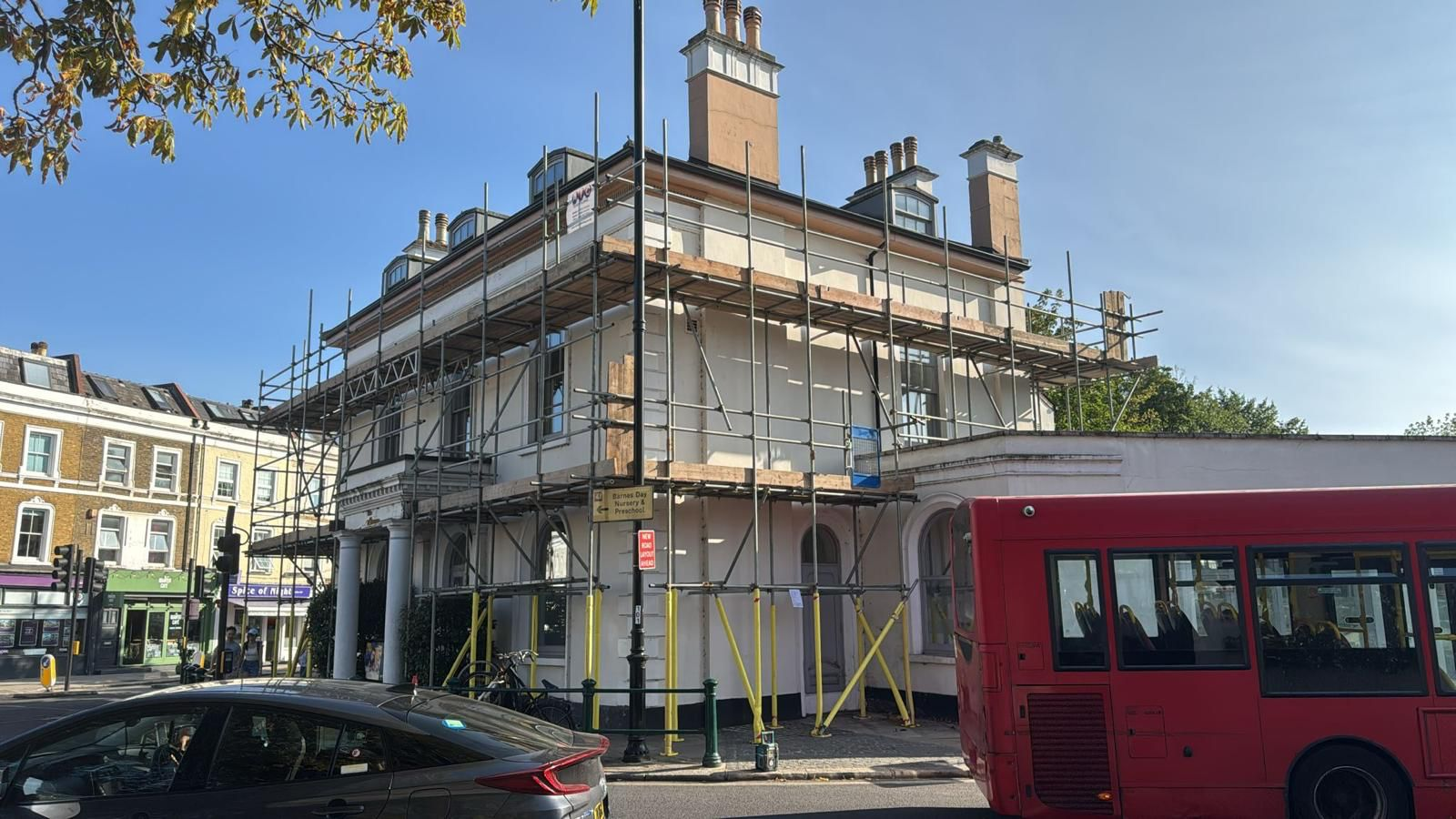Independent scaffold with boarded lifts erected around a period corner building on a London high street