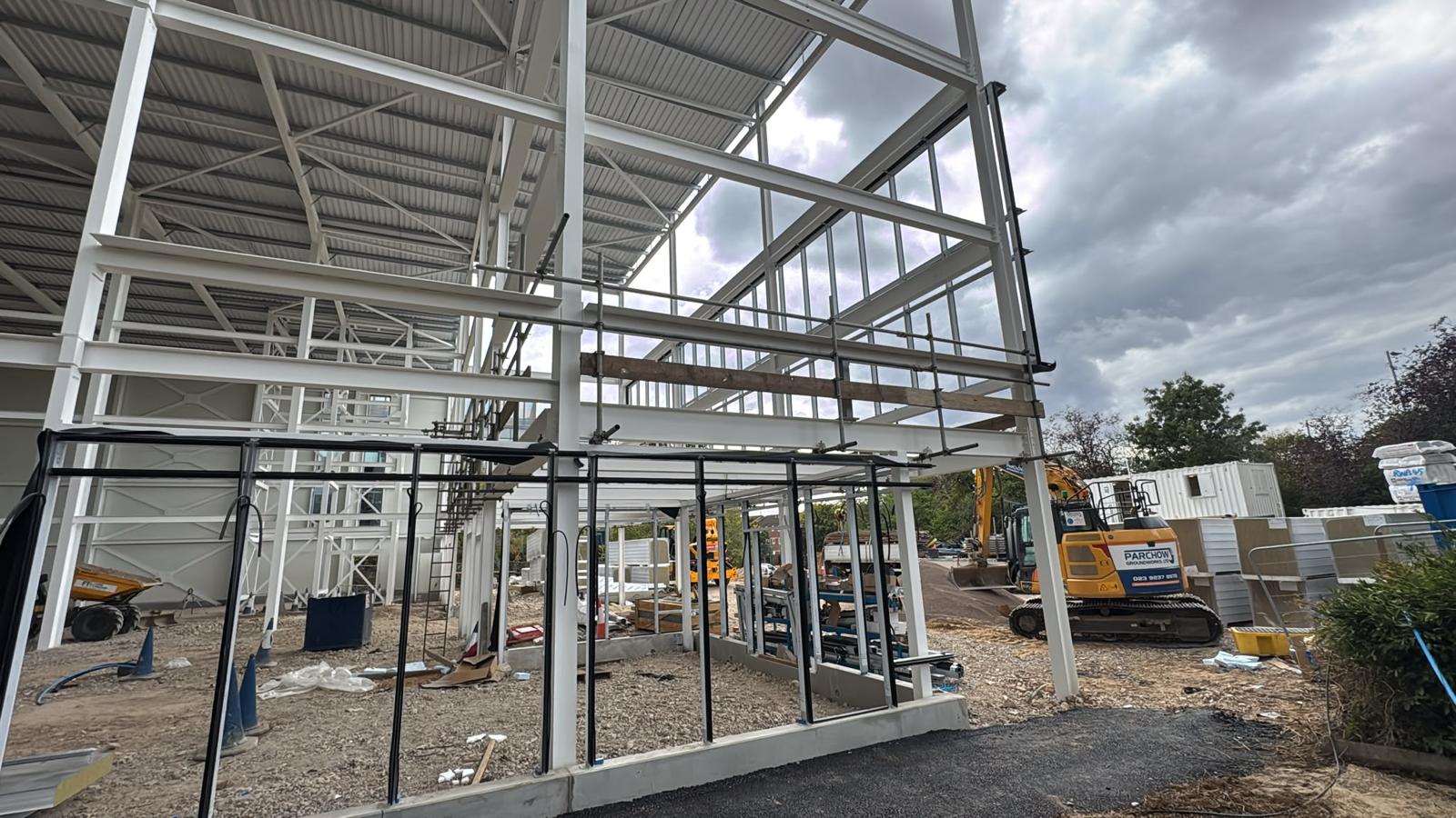 Edge protection guardrails fixed to the steel frame of a commercial unit during cladding and glazing works