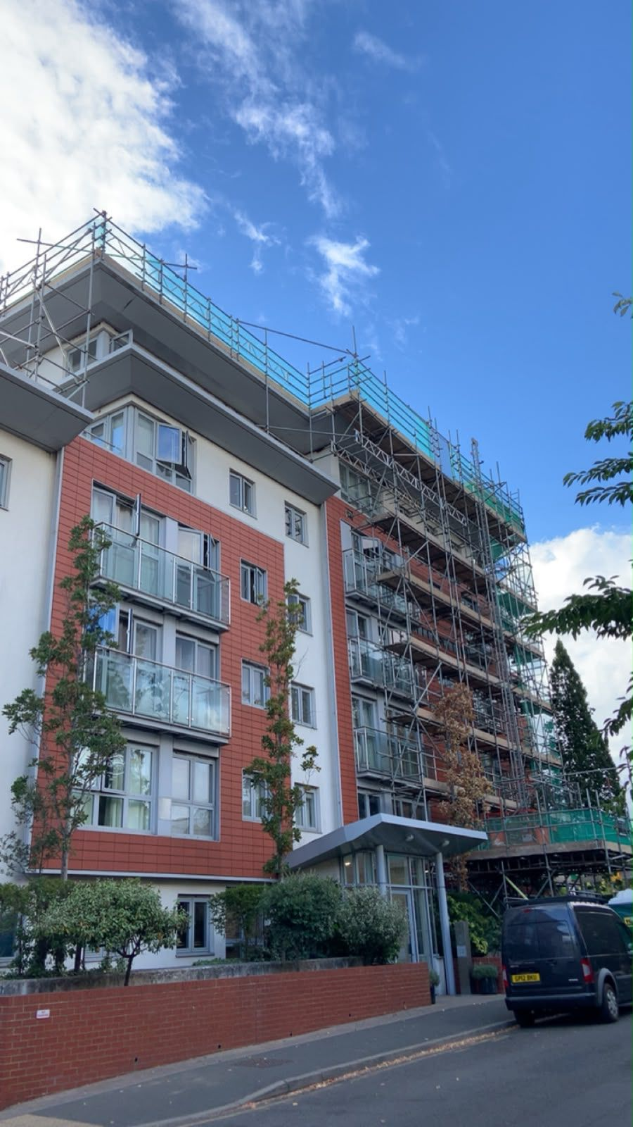 Full-height scaffolding erected across a multi-storey apartment block for facade and roof works