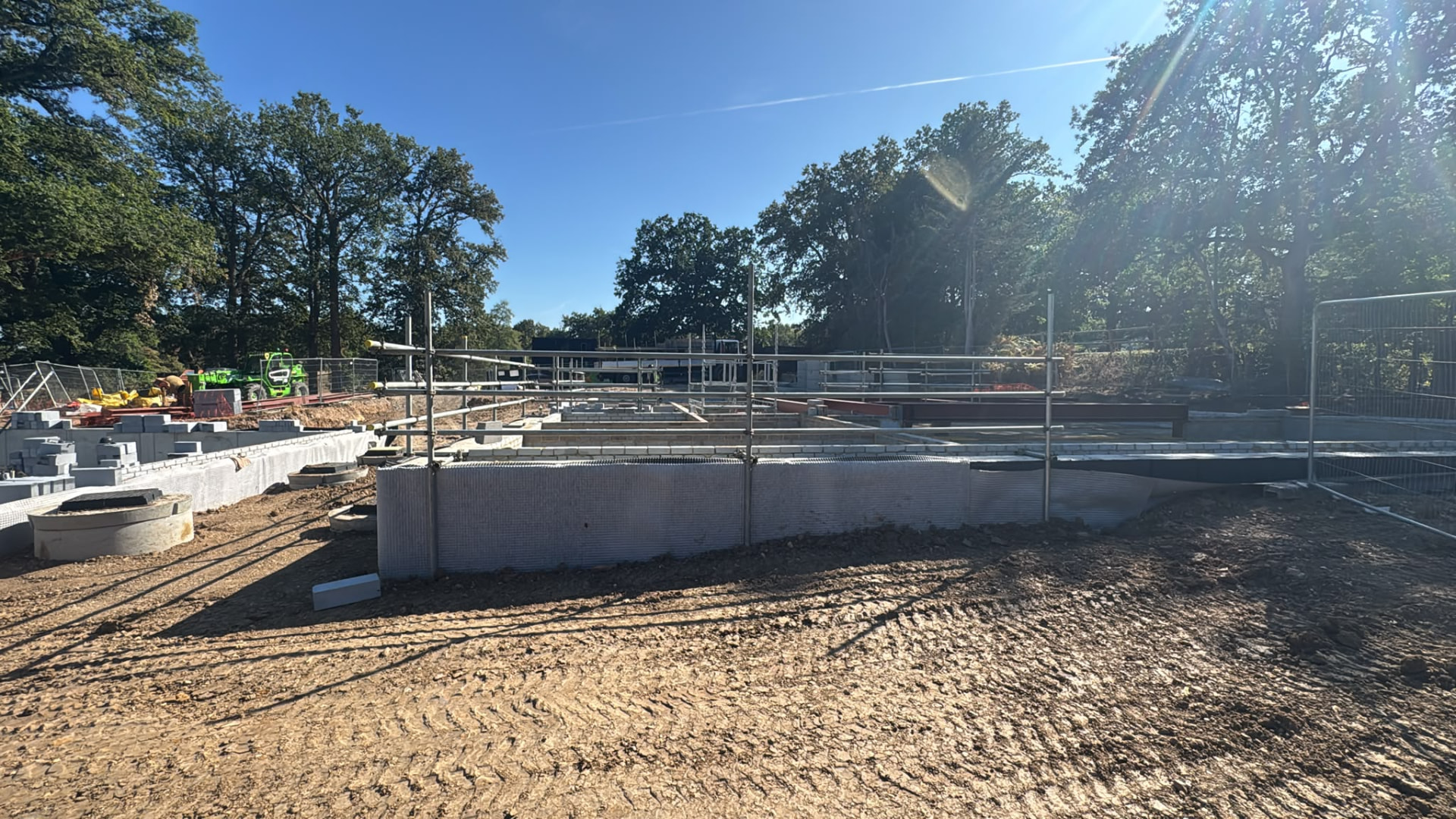 Temporary edge protection guardrails installed around the perimeter of a new build slab and blockwork foundations